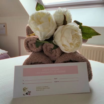 Carte cadeau et fleurs sur la table de massage